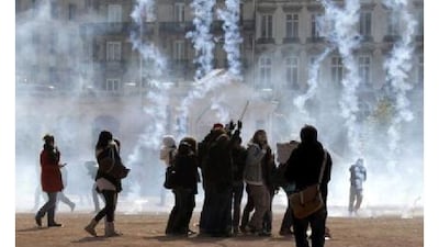 Youths group on the Place Bellecourt after police fired tear gas during a demonstration against pension reform in Lyon.