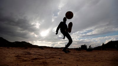 A Yemeni boy kicks up a football in the air during a match among friends and neighbours in the capital Sanaa. Mohammed Huwais / AFP