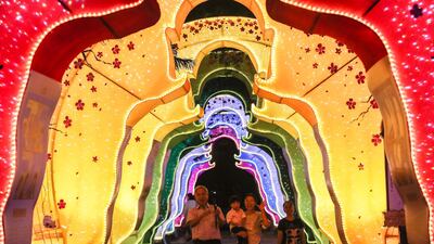 A family passes under a Buddha gate decoration at the Dong Zen temple in Jenjarom, Malaysia. EPA