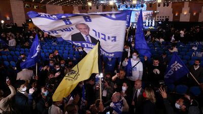 Supporters of Israeli Prime Minister Benjamin Netanyahu wave a flag depicting him as they react following the results of the exit polls in Israel's general elections at Netanyahu's Likud party headquarters in Jerusalem. Reuters
