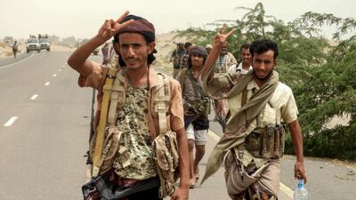 Yemeni pro-government forces flash the victory sign as they arrive in Al Duraihimi district, about nine kilometres south of Hodeidah international airport, on June 13, 2018. Nabil Hassan / AFP