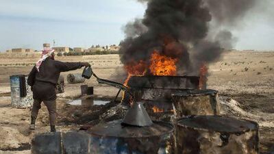 Ahmed, a 35-year-old farmer-turned-refiner, works on refining crude oil brought from Deir Ezzor province into a pit in the Al Raqqa countryside where it will be distilled as part of the refining process to produce fuel.