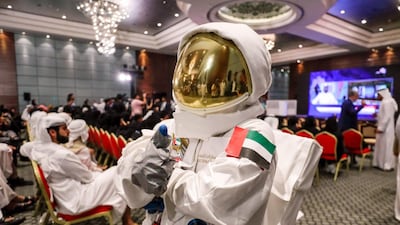 Saif Al Maskari dresses in a space suit to watch the launch at Abu Dhabi National Exhibition Centre on Wednesday. Victor Besa / The National