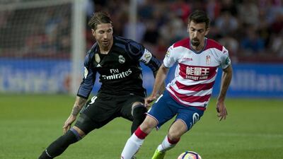 Granada midfielder Isaac Cuenca, right, vies with Real Madrid defender Sergio Ramos. Sergio Camacho / AFP