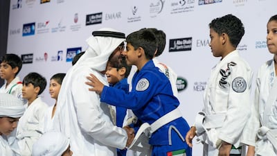 Sheikh Mohammed bin Zayed Al Nahyan Crown Prince of Abu Dhabi Deputy Supreme Commander of the UAE Armed Forces (L), greets a young participant during the Abu Dhabi Jiu-Jitsu Festival. Mohamed Al Hammadi / Crown Prince Court - Abu Dhabi