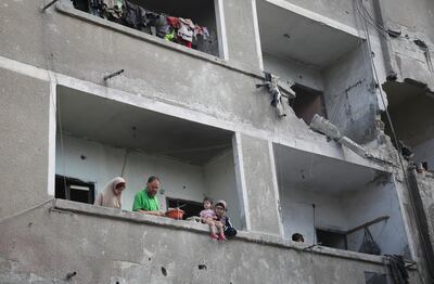 Palestinians stand on a balcony of a damaged house at the site of an Israeli strike in Rafah on Monday. Reuters