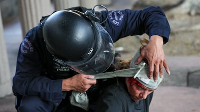 An activist receives care from a police officer. EPA