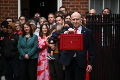 The UK Chancellor, John Healey, holds up the red box in Downing Street. Getty Images