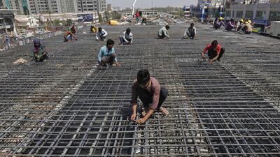 Workers fasten iron rods together at the construction site of a flyover on the outskirts of Ahmedabad, India, February 26, 2016. India expects its economy to grow 7-7.75 percent in the fiscal year to March 2017, a key government report said on Friday, ahead of the presentation of the annual budget by Finance Minister Arun Jaitley on Monday. REUTERS/Amit Dave