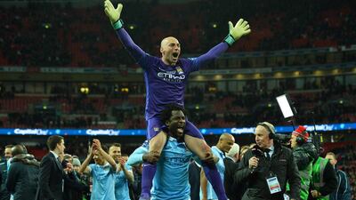 Manchester City’s Argentinian goalkeeper Willy Caballero (top) celebrates on the shoulders of Manchester City’s Ivorian striker Wilfried Bony (C bottom) after he saved three penalties in the penalty shoot-out to help Manchester City win the English League Cup final football match between Liverpool and Manchester City at Wembley Stadium in London on February 28, 2016. AFP / GLYN KIRK