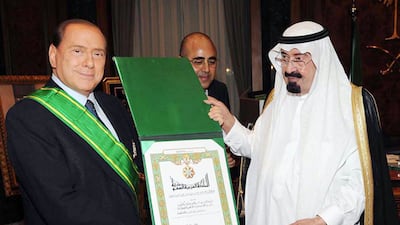 A handout picture from the Saudi Press Agency (SPA) shows Saudi King Abdullah bin Abdul Aziz (R) decorating Italian Prime Minister Silvio Berlusconi with the King Abdul Aziz medal during a meeting in Jeddah, late on November 21, 2009. Berlusconi paid a previously unannounced visit to Middle East oil powerhouse Saudi Arabia, the state news agency SPA reported. AFP PHOTO/HO/SPA == RESTRICTED TO EDITORIAL USE == (Photo by SPA / AFP)
