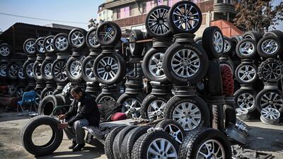 A worker inspects a tyre at a shop in Kabul. AFP