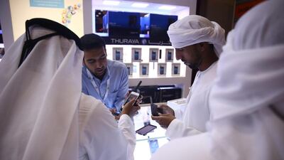 Visitors look at satellite phones on display. Warren Little / Getty Images