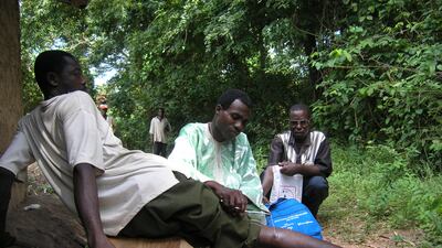 A volunteer in Nigeria inspects a Guinea worm emerging from a man's calf. Guinea worm is on track to become the second human disease, and the first parasitic infection, to be eradicated as cases hit an all-time low.
