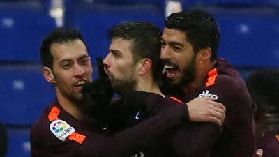 Barcelona defender Gerard Pique, centre, celebrates with Sergio Busquets and Luis Suarez after scoring a headed equaliser against Espanyol. Albert Gea / Reuters