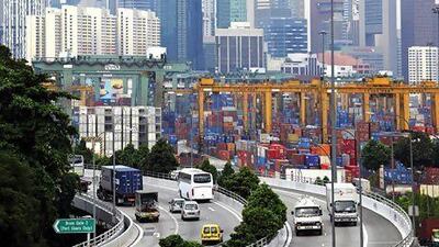 Singapore's central business district forms a backdrop to shipping containers stacked at the city state's port. Munshi Ahmed / Bloomberg News