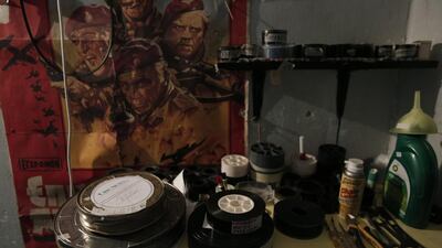 Film and tools lie on a table next to a poster of the 1978 war movie Wild Geese, starring Richard Burton, at the Amigo outdoor cinema in Halandri, north of Athens.
