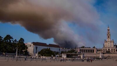 Smoke billows above the Sanctuary of Our Lady of Fatima, after a fire broke out in Fatima, Portugal. AFP