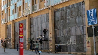 Workers fix iron shields on the storefronts to protect them from cracking during riots during upcoming demonstrations in downtown Beirut, Lebanon. EPA
