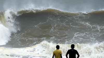 Two men look out at rough seas off Colombo caused by winds from Cyclone Ockhi on November 30, 2017. Ishara S Kodikara / AFP