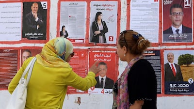 Women look at posters of Tunisian presidential candidates in Tunis on September 2, 2019, the first day of the campaign period. AFP