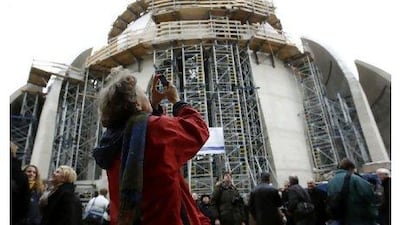 A woman takes a photo during the roofing ceremony of a new large mosque in the Cologne suburb of Ehrenfeld on February 2, 2011.
