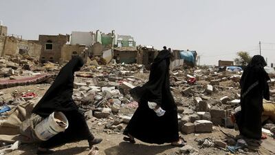 Women walk at the site of an air strike that hit a residential area last month near Sanaa airport on May 18. Reuters