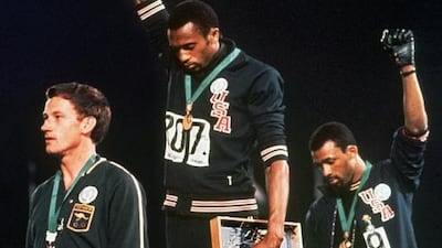 In this October 16, 1968 photo, US athletes Tommie Smith, centre, and John Carlos, right, stare downward during the playing of the "Star-Spangled Banner" after Smith received the gold and Carlos the bronze in the 200 metre run at the Summer Olympic Games in Mexico City. On the left is Peter Norman. AP Photo