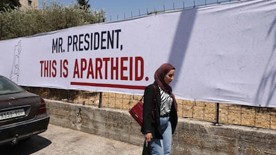 A woman walks past a poster that is part of a campaign organised by Israeli human rights group B'Tselem in the city of Bethlehem. AFP
