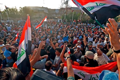 Dozens of Iraqis shout slogans and wave national flags during a demonstration outside the local government headquarters in the southern city of Basra. AFP