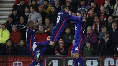Manchester United's Wayne Rooney, centre, leaps into the arms of Robin van Persie after Van Persie's opening goal in their Premier League win on Monday night. Adrian Dennis / AFP