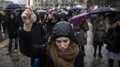 A young woman holds aloft a pen as she joins others for a minutes silence in front of Notre Dame cathedral in memory of the 12 victims killed outside the Charlie Hebdo magazine headquarters, in Paris, France, 08 January 2015. Ian Langsdon / EPA
