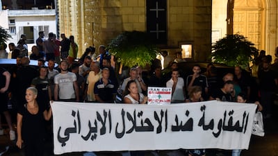 People carry a banner that reads in Arabic 'The resistance against the Iranian occupation'. EPA