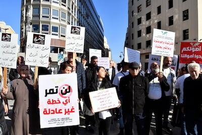 Bank customers and Depositors Association members hold placards during a protest against the draft banking bill. EPA