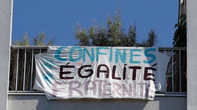 "Confined, equality, fraternity" says a banner hanging from a window in Paris. AFP