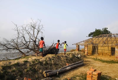 Indian children play on the coast affected by erosion on the Ghoramara Island. AFP