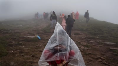 A devotee wears a plastic cape during a summer rain shower while trekking to reach Gosaikunda Lake. Narendra Shrestha/EPA