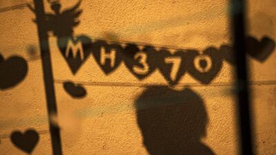 A shadow shows people hanging a message during an event ‘Love U MH370’ in Kuala Lumpur, Malaysia. Ahmad Yusni / EPA