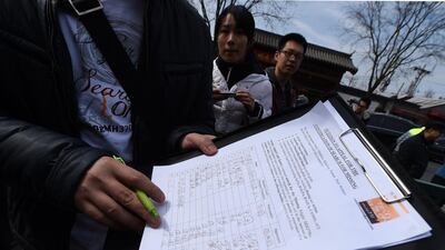 A family member of a Chinese passenger from the flight MH370 shows a signed petition to urge for the continuation of the search of the plane. Goh Chai Hin / AFP Photo