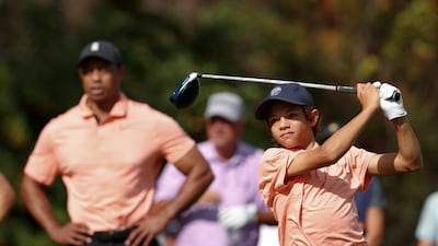 Charlie Woods tees off while being watched by father Tiger Woods on the first tee during the first round of the PNC Championship golf tournament Saturday, December 18, 2021, in Orlando. AP