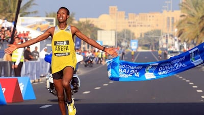 Ethiopian runner Tsegaye Mekonnen Asefa crosses the finish line first at the Standard Chartered Dubai Marathon on Friday. AP Photo