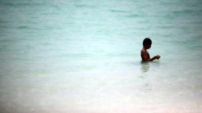 Ahmed Abdullah, 12, has the Corniche Beach in Abu Dhabi almost all to himself as he braves the heat.