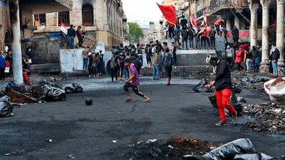 Anti-government protesters gather near barriers set up by security forces to close Rasheed Street during ongoing protests in Baghdad. AP Photo