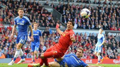 Liverpool’s Uruguayan striker Luis Suarez, centre, is challenged by Chelsea’s Serbian defender Branislav Ivanovic, right, during the English Premier League football match between Liverpool and Chelsea at Anfield Stadium in Liverpool, northwest England, on April 27, 2014. AFP PHOTO / ANDREW YATES