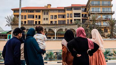Members of a Palestinian family look at Al Mathaf hotel, where their relatives are quarantined, to limit the spread of the coronavirus pandemic, in Gaza City. AFP