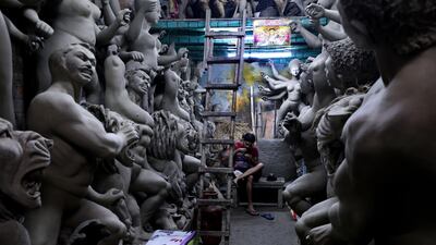 An Indian artist has lunch next to unfinished idols of Goddess Durga at Kumartuly district ahead of the Durga Puja festival in Kolkata, India. EPA