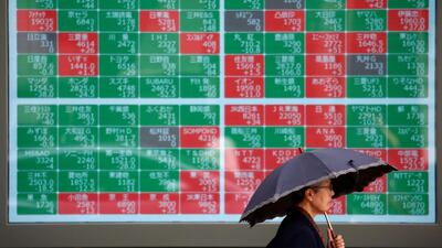 A passerby walks past in front of a stock quotation board outside a brokerage in Tokyo, Japan. Reuters
