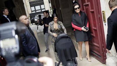 Kim Kardashian, centre, pushes a stroller next to her partner Kanye West, left, and her mother Kris Jenner, right, as they leave their hotel on May 23, 2014 in Paris. Kenzo Tribouillard / AFP photo