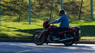 A man rides his motorcycle near a banner reading 'Plan v plan. Resistance v blockade. For Cuba: United' in Havana. AFP