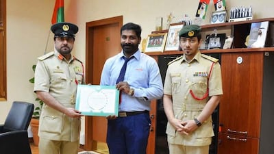 Dubai bus driver Abhishek Nad Gobindhan receives a certificate of thanks from Dubai Police. Courtesy: Dubai Police